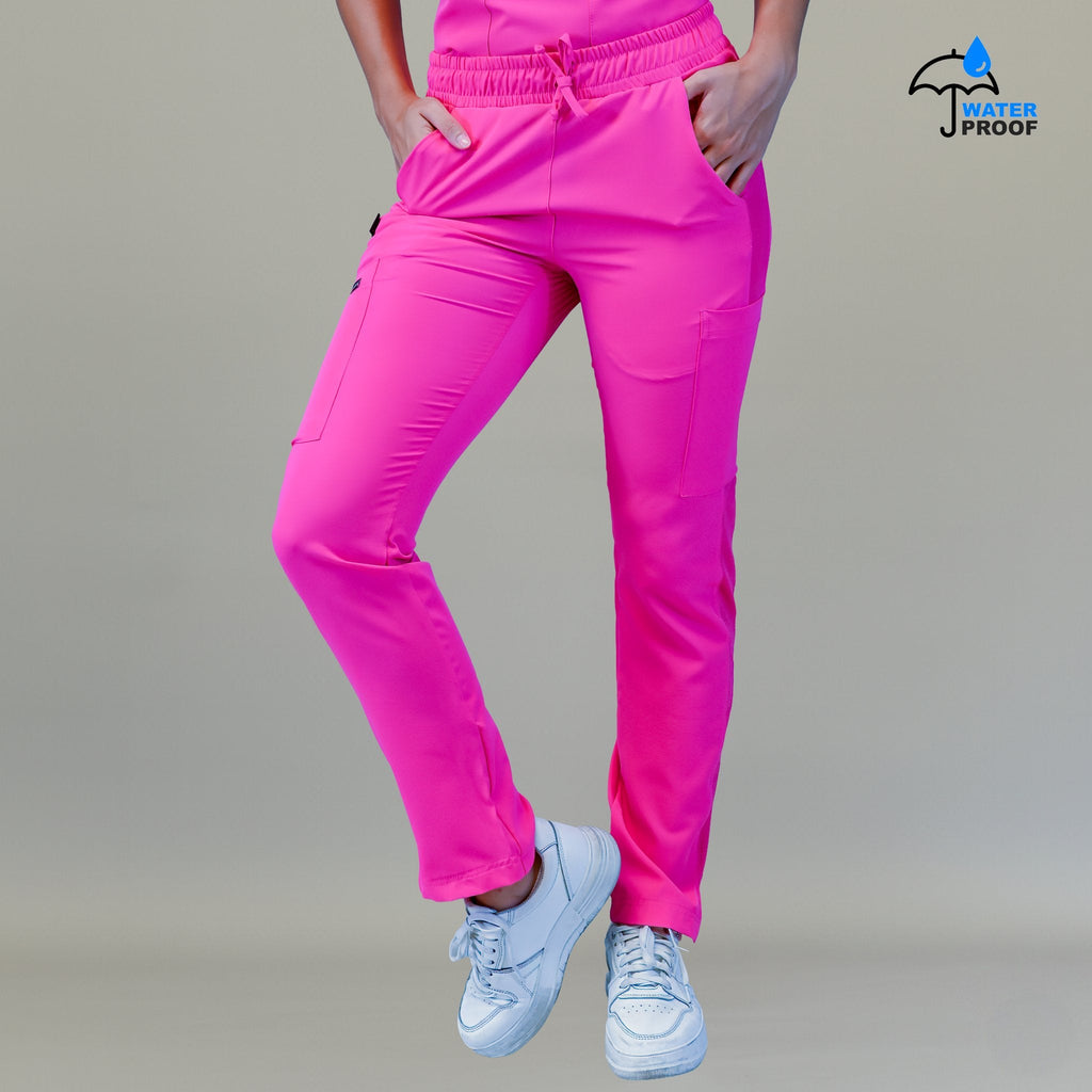 Pantalón quirúrgico mujer 530 rosa fiusha visto de frente con las manos de la modelo en los bolsillos.