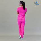 Vista completa de espaldas de modelo vistiendo el conjunto médico con pantalón quirúrgico rosa fiusha.