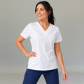 Women's white lightweight scrub top 502 V-neck with hand on hip — fluid-resistant medical uniform for nurses by S-FOR-ME