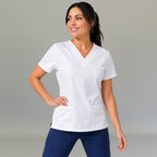 Women's white lightweight scrub top 502 V-neck with hand on hip — fluid-resistant medical uniform for nurses by S-FOR-ME