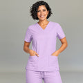 Women's lilac lightweight scrub top 502 V-neck front view with both hands in pockets — fluid-resistant medical uniform by S-FOR-ME