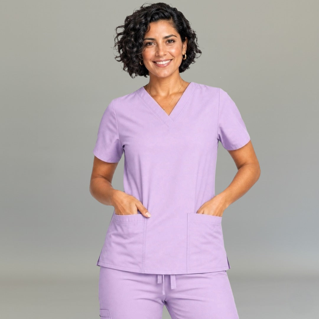 Women's lilac lightweight scrub top 502 V-neck front view with both hands in pockets — fluid-resistant medical uniform by S-FOR-ME