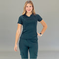 Front view of airforce blue scrub top on model standing with hands relaxed.