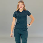 Front view of airforce blue scrub top on model standing with hands relaxed.