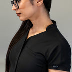 Neckline, zipper and chest pocket detail on Black scrub jumpsuit