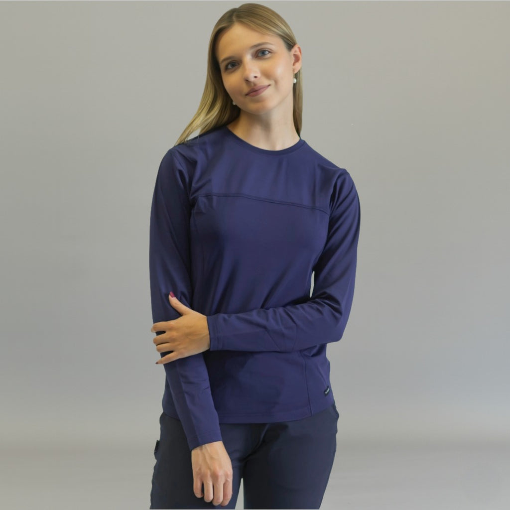Front view of a woman wearing a navy blue long sleeve underscrub.