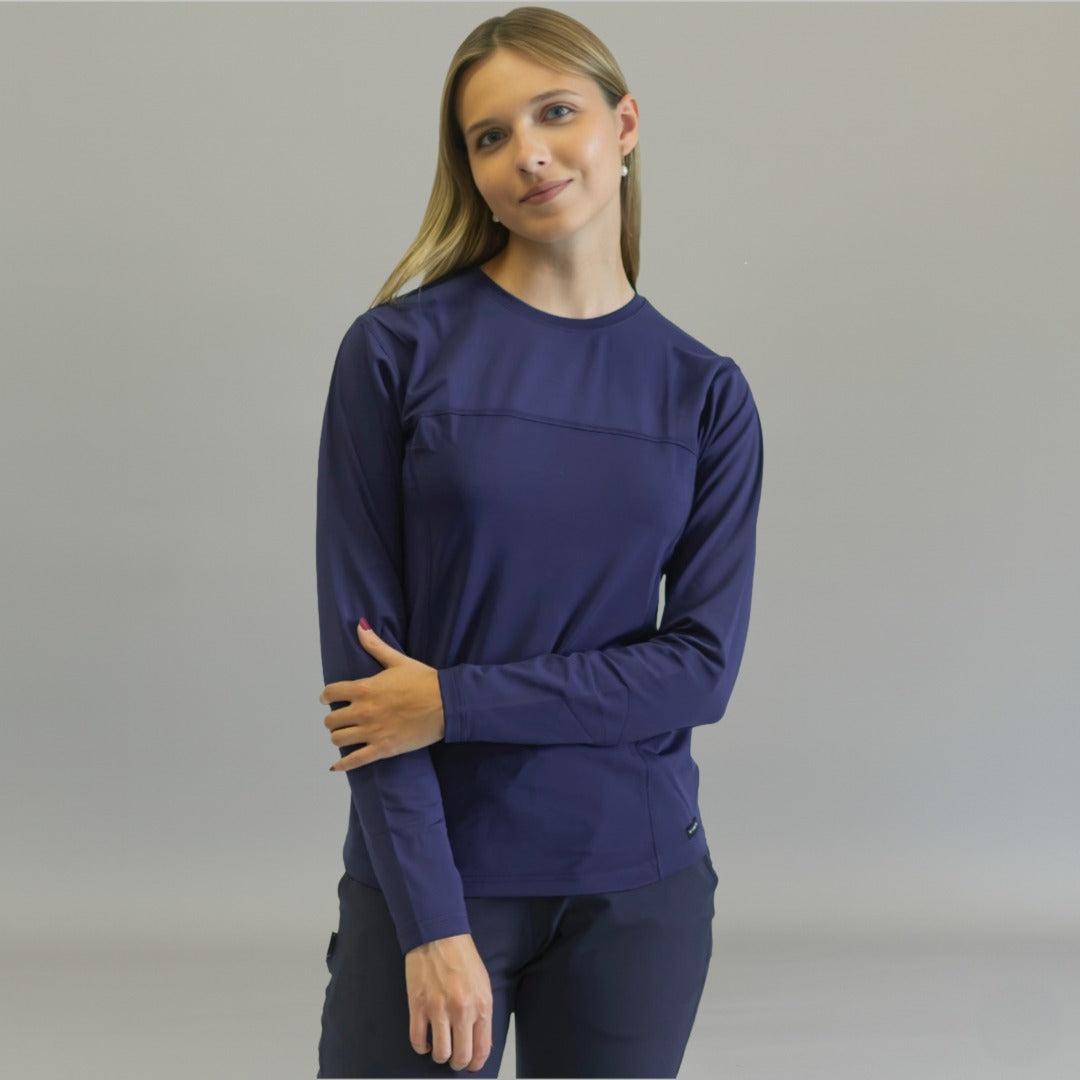 Front view of a woman wearing a navy blue long sleeve underscrub.