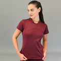 Woman wearing maroon Women's Top 910 Super Stretch Scrubs, looking to the side with hands near hips.