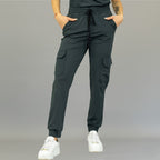 Front view of women's oxford gray scrub jogger pants with hands in pockets.