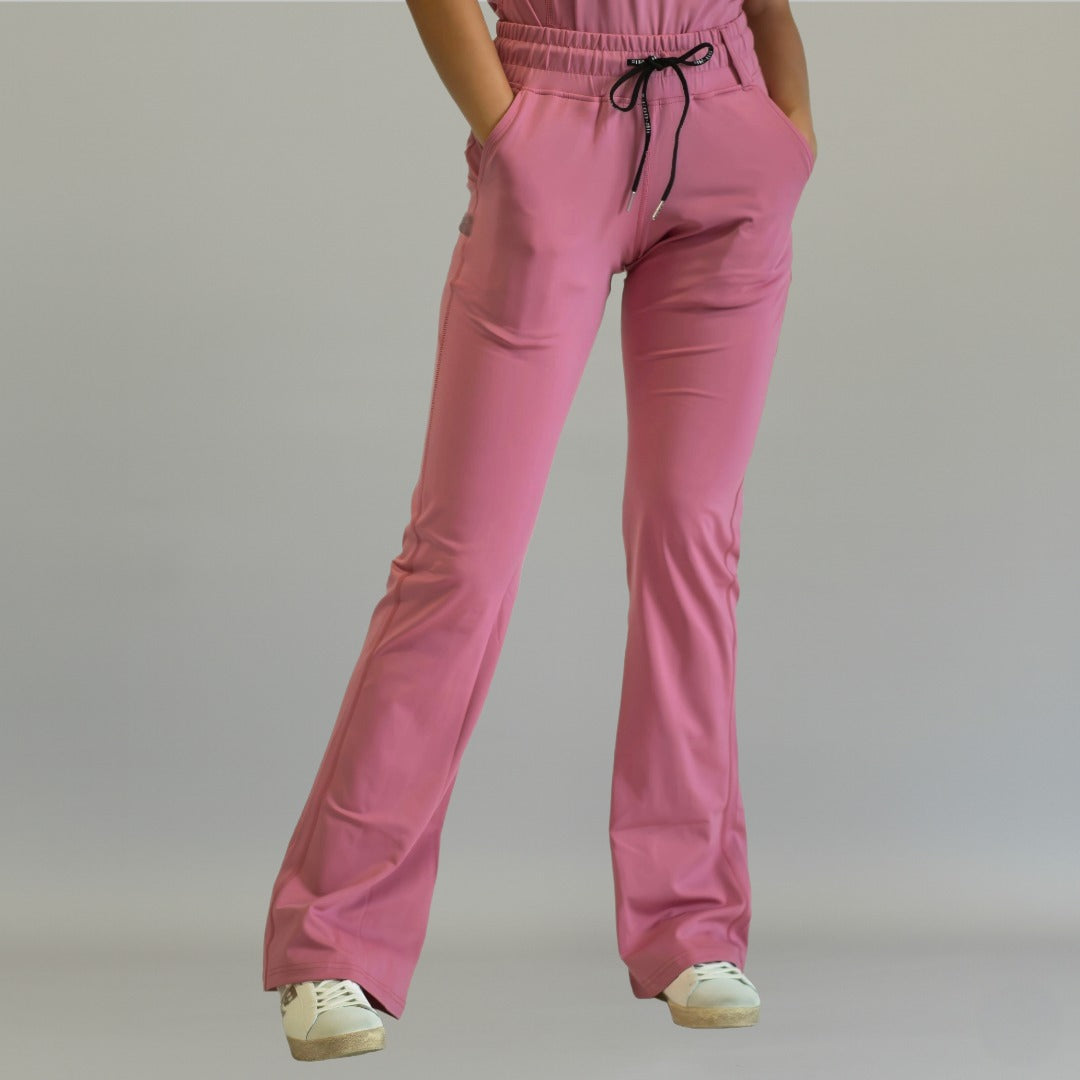 Women's mauve rose flare scrub pants, front view with one leg crossed