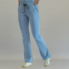 Women's sky blue flare scrub pants, front view with one leg forward