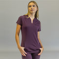 Women's purple scrub top, Style 915, front view with model's hands in pockets