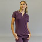 Women's purple scrub top, Style 915, front view with model's hands in pockets