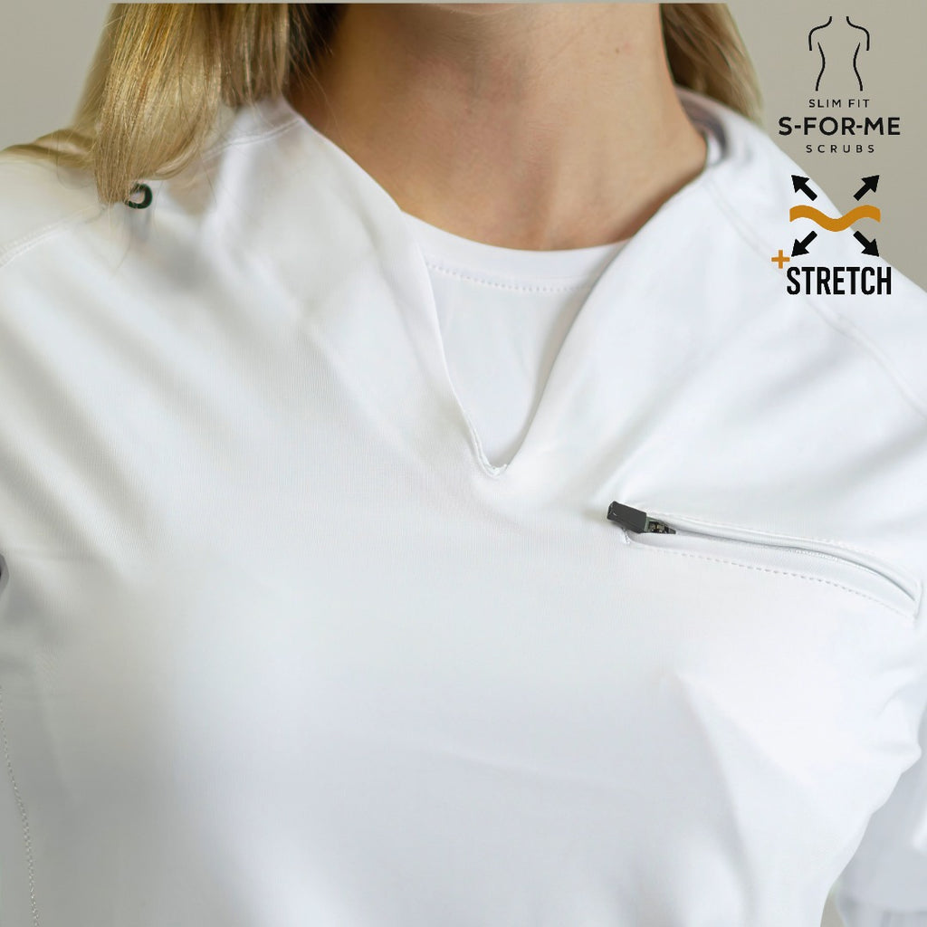 Women's 915 White scrub top — seated pose showing stretch and comfort during long shifts