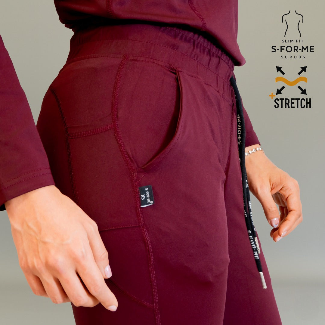 Close-up side view of Women’s 915 maroon scrub pants showing pocket, elastic waistband and drawstring